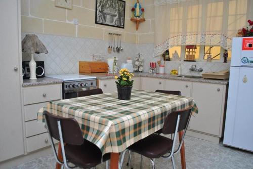 a kitchen with a table with a checkered table cloth at St Nicholas Crt in Munxar