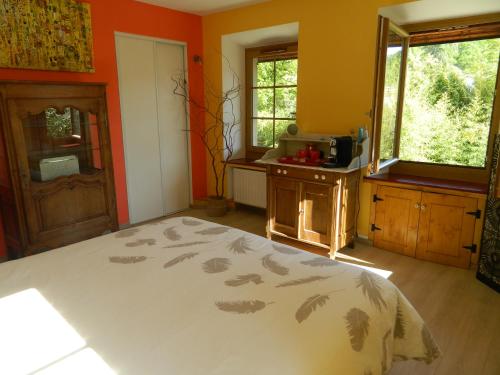 une chambre avec des murs orange et un lit dans une pièce dans l'établissement Gite de l'école, à Barby