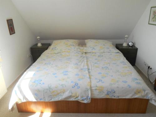 ラーボエにあるFerienwohnung-Moltrecht-1のベッド(白い掛け布団、青と黄色の花付)