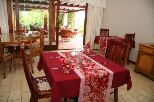 a dining room with a table with a red table cloth at Hildesheim Guest Lodge in Wilderness