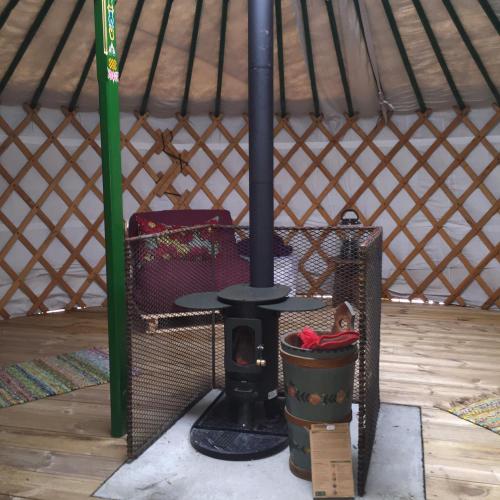 a stove in a yurt with a table in it at The Yurt in Isle of Gigha