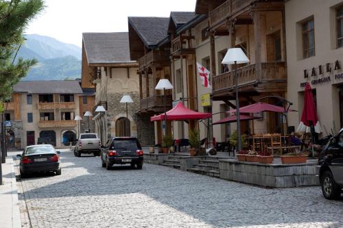 a street in a town with cars driving down the street at N&N Guest House in Mestia