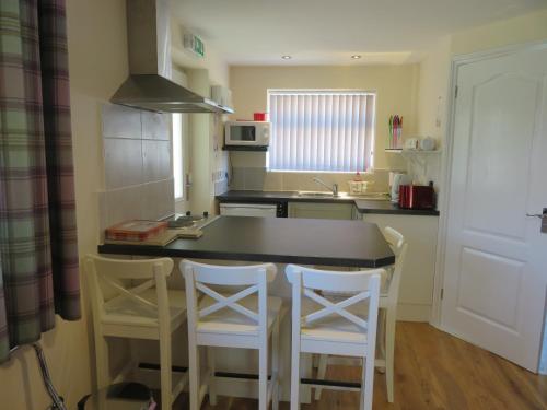 a kitchen with a table and four chairs in it at Apple Tree Corner Apartment in Yate