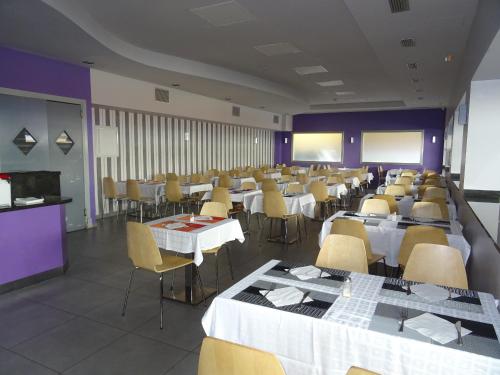 een grote kamer met tafels en stoelen en een klaslokaal bij Hotel TossaMar in Tossa de Mar