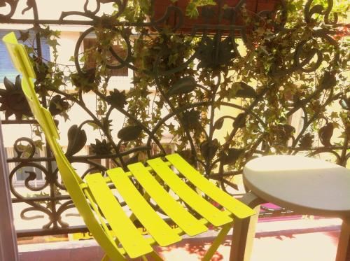a yellow chair sitting next to a plant at Hôtel Brimer Cannes in Cannes