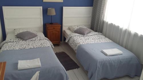2 letti in una camera con pareti blu di Mirka Apartment a Gdynia