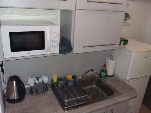 a kitchen counter with a sink and a microwave at Hostel Sopot Centrum in Sopot
