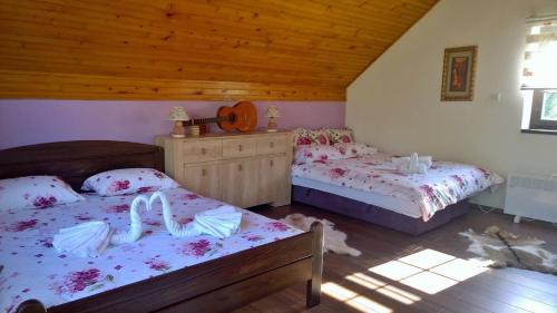 a bedroom with two beds and a wooden ceiling at Apartment Holiday - River view beside Pyramid in Visoko