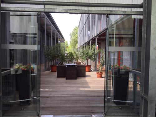 an internal corridor of a building with potted plants at Orange Wings Krems in Krems an der Donau