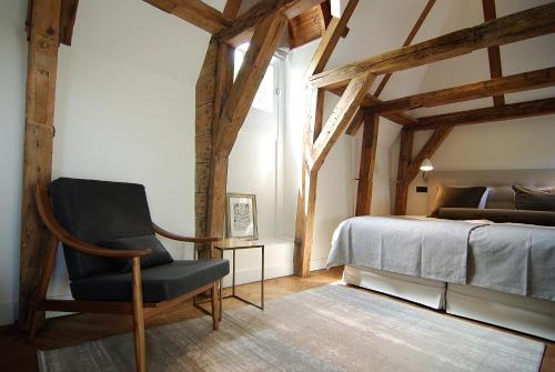 - une chambre avec une chaise à côté d'un lit dans l'établissement The Bolster, à Amsterdam