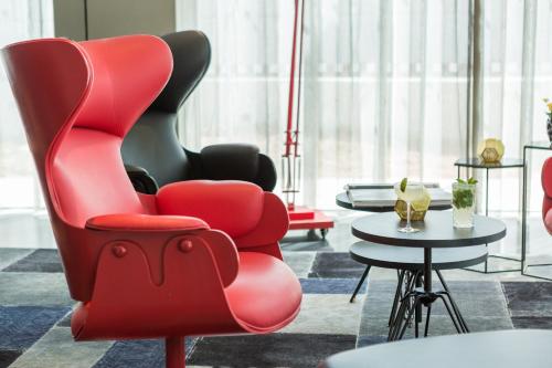 a red chair in a room with a table at Park Plaza London, Park Royal in London