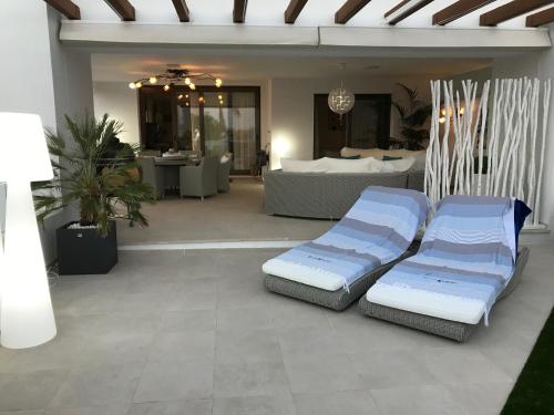 2 Betten auf einer Terrasse mit einem Wohnzimmer in der Unterkunft Estepona Luxe top appartement in finca de cortesin d38 in Estepona