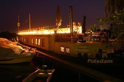 a boat is docked in a harbor at night at Schiffspension Luise in Potsdam