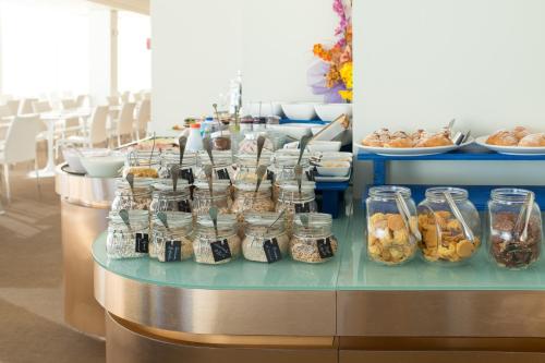a buffet with many jars of food on a table at Hotel Commodore in Riccione