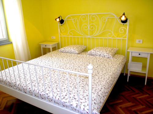 a bedroom with a white bed in a yellow room at Holiday Home Lija Center in Rab