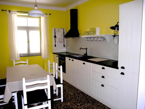 a kitchen with yellow walls and a table and a sink at Holiday Home Lija Center in Rab