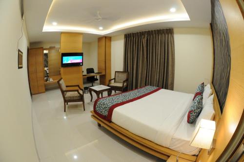 a hotel room with a bed and a dining room at Hotel Grand Rajputana in Raipur