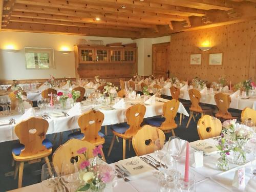 a room filled with tables and chairs with flowers on them at Hotel Saluver in Celerina