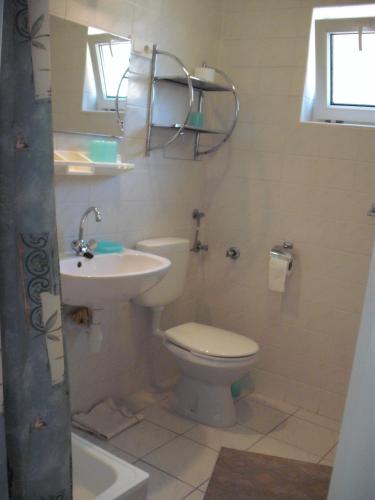a bathroom with a toilet and a sink at Apart Hévízi Ház in Hévíz