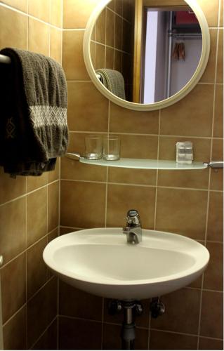 y baño con lavabo y espejo. en House Raduha - depandansa en Luče
