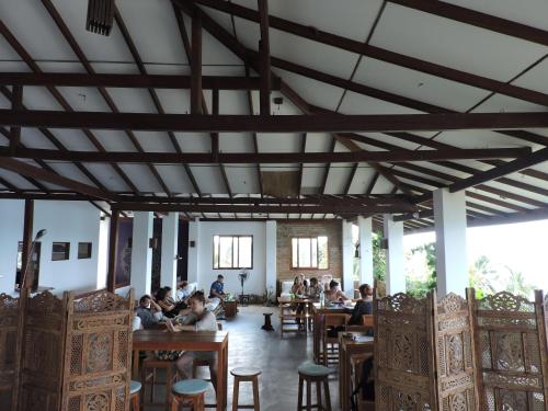 a group of people sitting at tables in a restaurant at Bay Vista in Arugam Bay