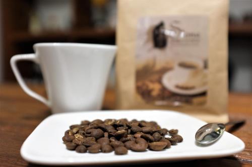 Ein Teller mit Kaffeebohnen und ein Löffel stehen auf einem Tisch. in der Unterkunft INg Hostel in Hualien