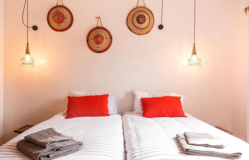 a bedroom with two beds with red and white pillows at Number5 Guesthouse in Cape Town