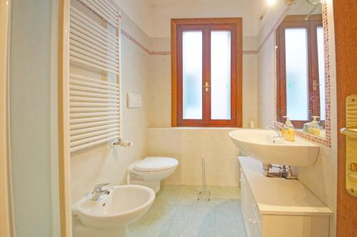 a white bathroom with a sink and a toilet at DolceVita Apartments N 382 in Venice