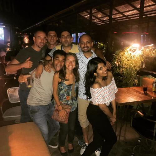 a group of people posing for a picture in a bar at The Little Blue Window Hostel in Bengaluru