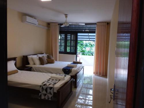 a hotel room with two beds and a window at Colombo Residence in Colombo