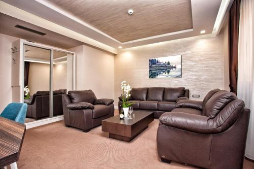 a living room with brown leather furniture and a table at Wellness & Spa Hotel ACD in Herceg-Novi