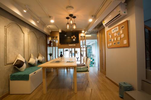 a room with a table and a couch and a tv at PAMAhouse Boutique Hostel in Bangkok