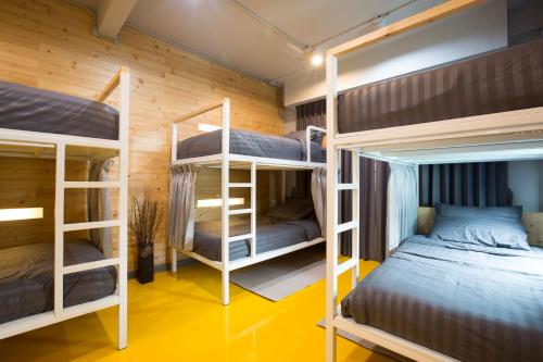 two bunk beds in a room with yellow floors at PAMAhouse Boutique Hostel in Bangkok