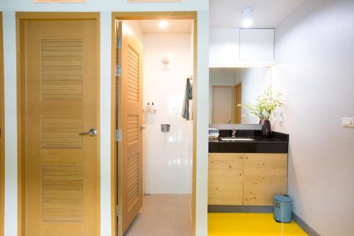 two images of a kitchen with a door and a sink at PAMAhouse Boutique Hostel in Bangkok