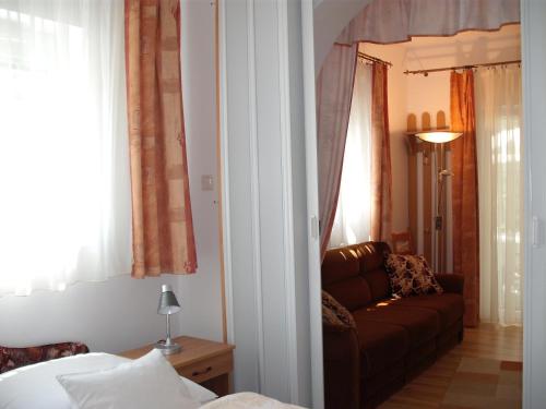 a living room with a couch and a bed at Apart Hévízi Ház in Hévíz