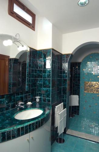 フィレンツェにあるMichelangiolo Penthouseの緑のタイル張りのバスルーム(シンク、鏡付)