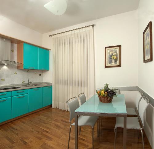 フィレンツェにあるMichelangiolo Penthouseのキッチン(青いキャビネット、テーブル、椅子付)