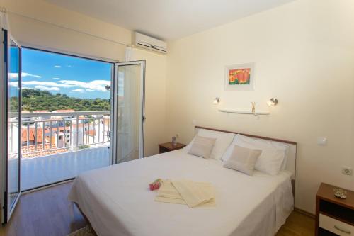 1 dormitorio con 1 cama grande y balcón en Vucic Apartments, en Hvar