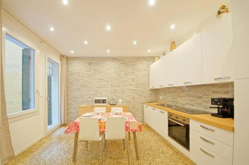 une cuisine avec une table et des placards blancs dans l'établissement DolceVita Apartments N 374, à Venise