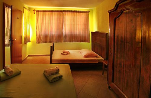 a small bedroom with two beds and a window at Hill House Marija in Komiža