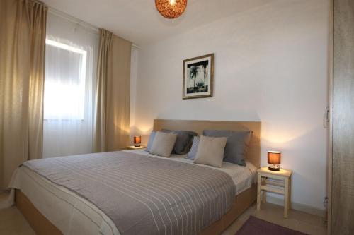 Un dormitorio con una cama grande con dos lámparas. en Apartments Baresic, en Šilo