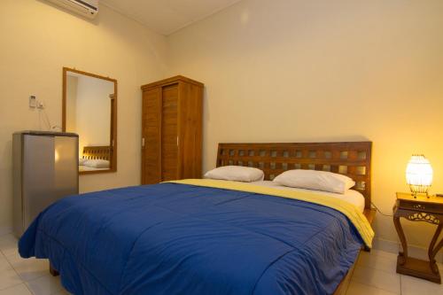 沙努爾的住宿－彭多克努利民宿，一间卧室配有一张带蓝色毯子的大床
