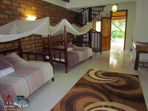 Secrets Guest House tesisinde bir odada yatak veya yataklar