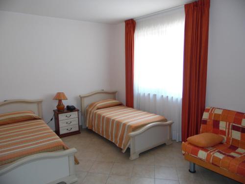 En eller flere senge i et værelse på Hotel Coste Del Lago
