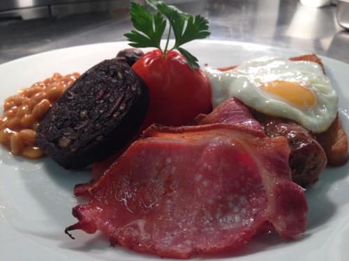 a plate of food with eggs meat and beans at Red Lion Inn in Newbrough