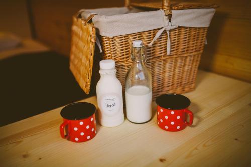 two bottles and two cups on a table with a basket at Green Resort Glamping in Radlje ob Dravi