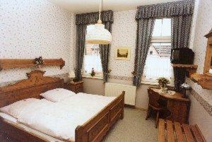 - une chambre avec un lit, une table et des fenêtres dans l'établissement Altstadtgasthof Krone, à Eschwege