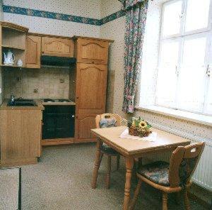 eine Küche mit einem Tisch, einem Tisch und einem Fenster in der Unterkunft Altstadtgasthof Krone in Eschwege