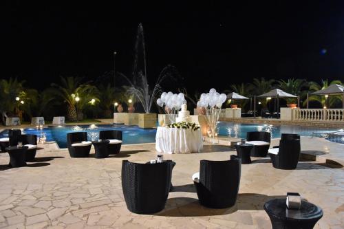 a pool with chairs and a fountain at night at Tenuta Caradonna in Lequile