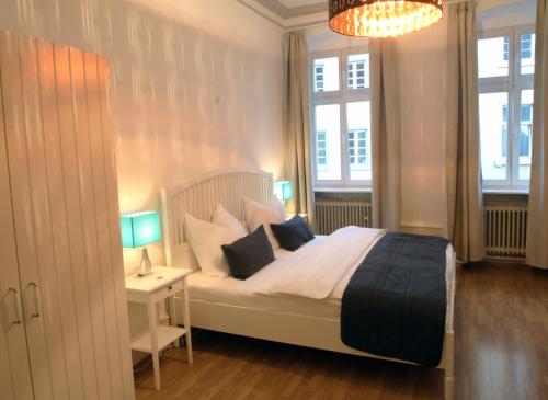 a bedroom with a bed with pillows and a chandelier at Hotel Sudpfanne in Heidelberg